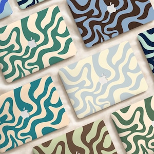Può includere: Una collezione di skin per laptop con vari motivi astratti ondulati in combinazioni di colori che includono verde bosco, crema, azzurro, marrone scuro e verde acqua. Ogni skin presenta un ritaglio centrale per il logo Apple sul coperchio.