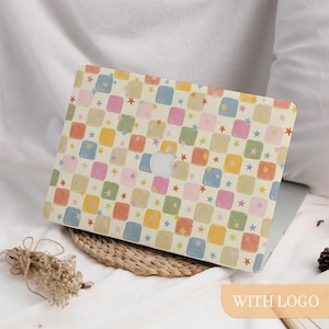 May include: A laptop hard shell case featuring a repeating pattern of rounded squares in muted shades of pink, blue, yellow, and green on a cream background. Small, multi-colored stars are scattered throughout the grid, with a central cutout.