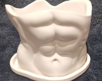 May include: White ceramic planter shaped like a human torso with defined abs. The planter has a separate saucer.