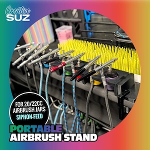 Puede incluir: Soporte portátil negro para aerógrafo con varios aerógrafos y mangueras de colores. El soporte tiene el texto "FOR 20/22CC AIRBRUSH JARS SIPHON-FEED PORTABLE AIRBRUSH STAND". El logotipo de Creative Suz está en la esquina superior izquierda. Para botes de aerógrafo de 20/22cc.