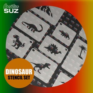 Op de afbeelding: Een set van 10 dinosaurus sjablonen, met verschillende dinosaurus silhouetten, waaronder een T-Rex, een Stegosaurus en een palmboom. De sjablonen zijn wit en zijn gerangschikt in een cirkel op een zwarte achtergrond. De tekst "Dinosaur Stencil Set" wordt weergegeven in een bruin rechthoek aan de onderkant van de afbeelding.