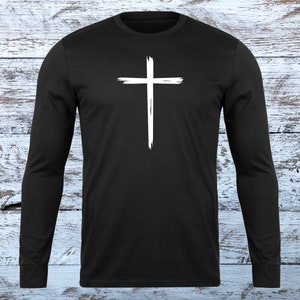 May include: Black long-sleeve shirt with a white, brushstroke-style cross graphic.