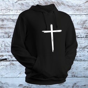 May include: Black hooded sweatshirt with a white distressed cross graphic on the front.
