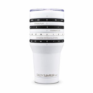 May include: A white tumbler with a clear lid featuring integrated black and white rotating rings for tracking golf statistics. The rings are labeled with numbers and text including STROKE PLAY, FAIRWAYS HIT, GREENS IN REGULATION, and TALLY TUMBLER GOLF.