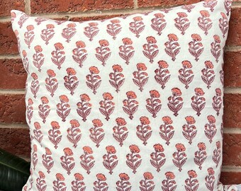 May include: A white cotton pillow cover with a repeating pattern of pink and burgundy floral designs.