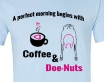 May include: A light blue t-shirt with a black and white illustration of a coffee cup and a goat. The text "A perfect morning begins with Coffee & Doe-Nuts" is printed on the shirt.