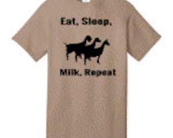 May include: A tan t-shirt with a black graphic of three goats and the text "Eat, Sleep, Milk, Repeat."