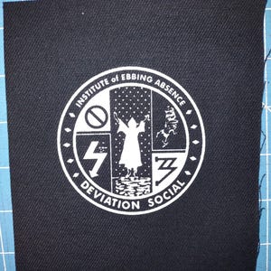 Puede incluir: Una taza de cerámica blanca con un asa negra y el texto "But First, Coffee" en negrita negra. La taza está sobre una superficie de madera. La taza mide aproximadamente 10 cm de alto.