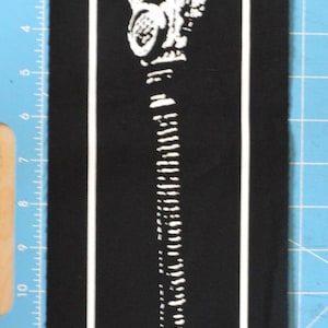 Op de afbeelding: Zwart-witte patch met een wit gasmaskerontwerp. Het gasmasker bevindt zich in het midden van de patch en is omgeven door een witte rand.