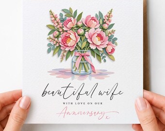 May include: A square greeting card featuring a watercolor illustration of a bouquet of pink peonies in a glass vase with a pink ribbon. The text reads beautiful wife with love on our Anniversary in black and pink script and serif fonts.