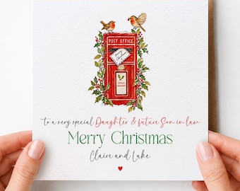 May include: A square white Christmas greeting card featuring a red post office box decorated with holly and two robins. The text reads: To a very special Daughter & future Son in law, Merry Christmas, Claire and Luke, with a small red heart.