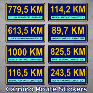 May include: A collection of blue rectangular stickers with yellow text, displaying distances in kilometers for various Camino de Santiago routes. The stickers include the text "Camino Route Stickers".