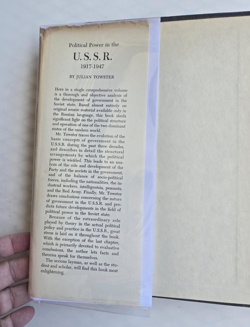 May include: A vintage book titled "Political Power in the U.S.S.R. 1917-1947" by Julian Towster. The cover is off-white with black text. The book is open, revealing the title and description of the book's contents.