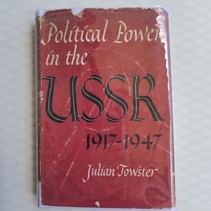 May include: A vintage book titled "Political Power in the USSR 1917-1947" by Julian Towster. The cover is a faded red with white and black lettering. The book shows signs of wear.