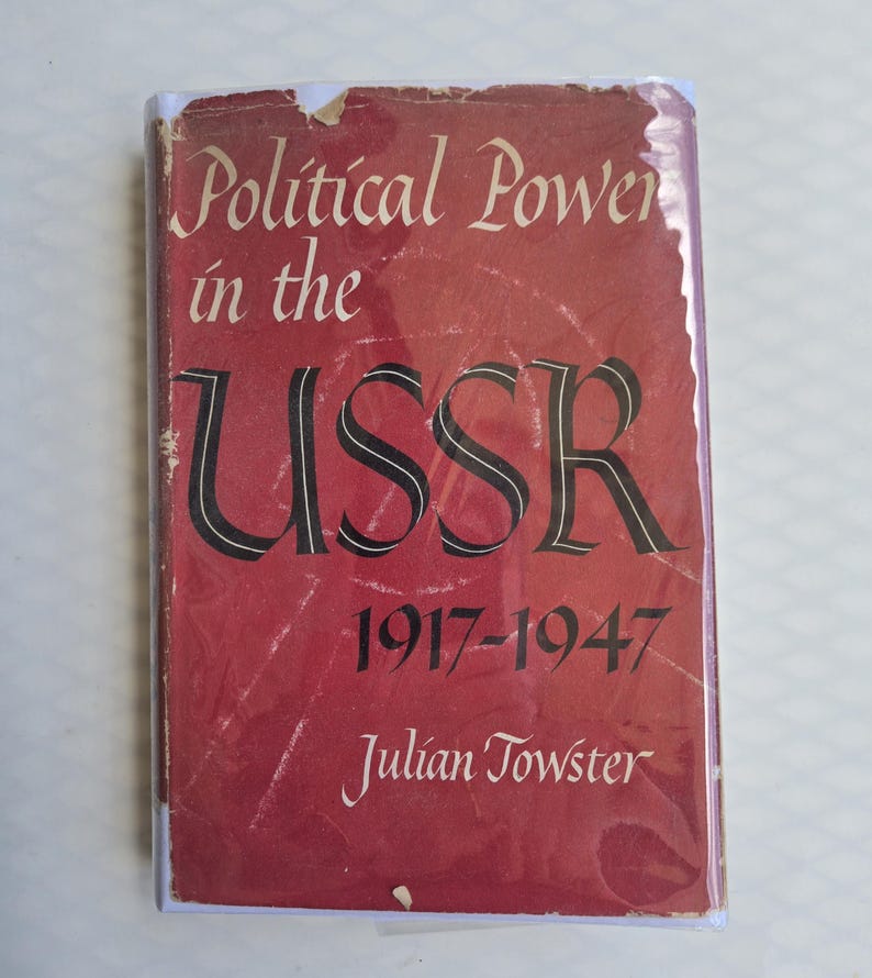 May include: A vintage book titled "Political Power in the USSR 1917-1947" by Julian Towster. The cover is a faded red with white and black lettering. The book shows signs of wear.