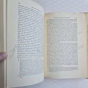 May include: Open book with text on aged paper. The pages are yellowed, and the text is in black. Handwritten notes are visible on the pages. The book is open to a double-page spread.