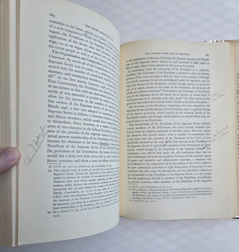 May include: Open book with text on aged paper. The pages are yellowed, and the text is in black. Handwritten notes are visible on the pages. The book is open to a double-page spread.
