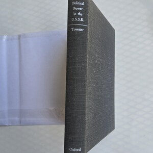 May include: A hardcover book titled "Political Power in the U.S.S.R." by Towster. The book has a dark gray cover with white text and the Oxford logo at the bottom. The book is standing upright.