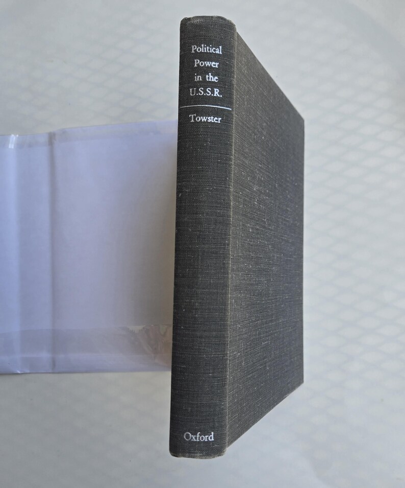 May include: A hardcover book titled "Political Power in the U.S.S.R." by Towster. The book has a dark gray cover with white text and the Oxford logo at the bottom. The book is standing upright.