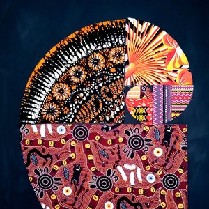 May include: A colorful abstract art piece featuring a spiral design made of different patterned fabrics. The spiral is made up of black, white, orange, red, yellow, and blue fabrics. The background is a dark blue.