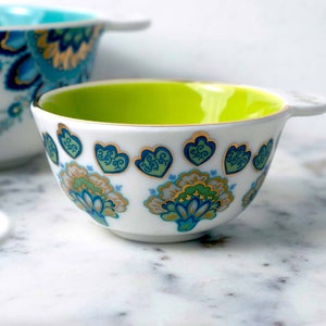 Detail of Mary DiSomma's beautiful and unique floral pattern design on white ceramic measuring cups.