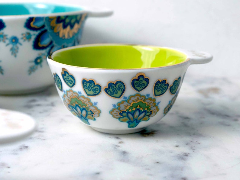 Detail of Mary DiSomma's beautiful and unique floral pattern design on white ceramic measuring cups.