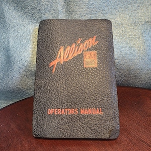 May include: A vintage Allison Operators Manual with a dark blue, textured cover. The title "Allison" is in red script, with the GM logo below. The words "OPERATORS MANUAL" are printed in red at the bottom.