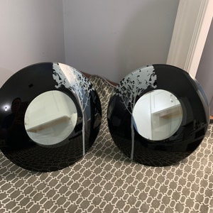 Może przedstawiać: Dwa czarne okrągłe lustra ścienne z białym wzorem drzewa. Lustra mają odblaskową powierzchnię.