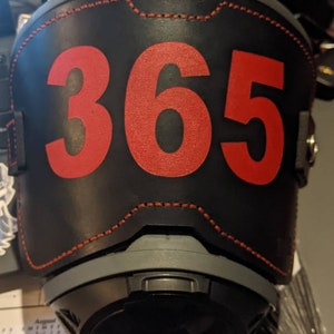 May include: Black leather helmet with red stitching and the number 365 printed in red.