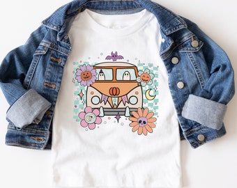 May include: White t-shirt with a colorful illustration of a vintage van with ghosts and pumpkins. The van has a "BOO" banner and is surrounded by flowers and stars.