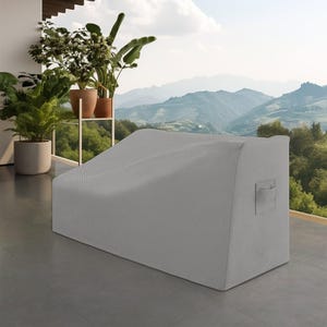 May include: A light gray, rectangular outdoor furniture cover made of a textured, woven fabric. The cover features a structured, sloped top design and includes a small, integrated fabric handle on the side panel for ease of handling and placement.