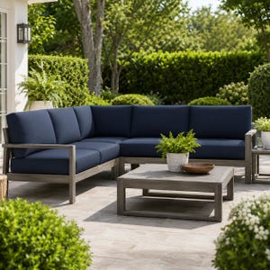 May include: An L-shaped outdoor sectional sofa with a weathered grey wooden frame and deep navy blue cushions, accompanied by a matching square coffee table. A small potted green plant and a wooden bowl sit on the table surface.