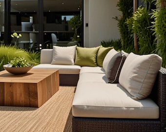 May include: An outdoor sectional sofa with beige cushions and dark brown wicker base. The sofa is adorned with beige, green, and brown pillows. A wooden coffee table and a woven rug complete the patio furniture set. A bowl of greenery sits on the table.