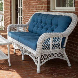 May include: White wicker loveseat with a blue cushion. The loveseat has a woven design and is perfect for outdoor use.