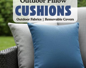 May include: Two outdoor throw pillows, one gray and one blue, on a wicker patio chair. The pillows have removable covers and are made from outdoor fabrics. The text "Outdoor Pillow CUSHIONS Outdoor Fabrics | Removable Covers" is displayed above the pillows.