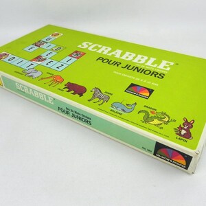 Pode incluir: Uma caixa de jogo de tabuleiro Scrabble Pour Juniors vintage. A caixa é verde limão com o título do jogo em branco e o texto "Pour Enfants de 6 à 10 Ans". A caixa apresenta ilustrações de animais e o logotipo Selchow & Righter.