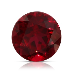 Può includere: Una pietra preziosa rotonda di colore rosso intenso con taglio a faccette. La pietra preziosa riflette la luce e ha una finitura lucida.