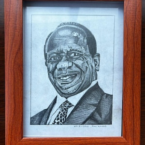 Può includere: Un disegno a matita in bianco e nero incorniciato di un uomo in abito e cravatta. Il disegno è firmato "11-8-2015, Rae Kassab."