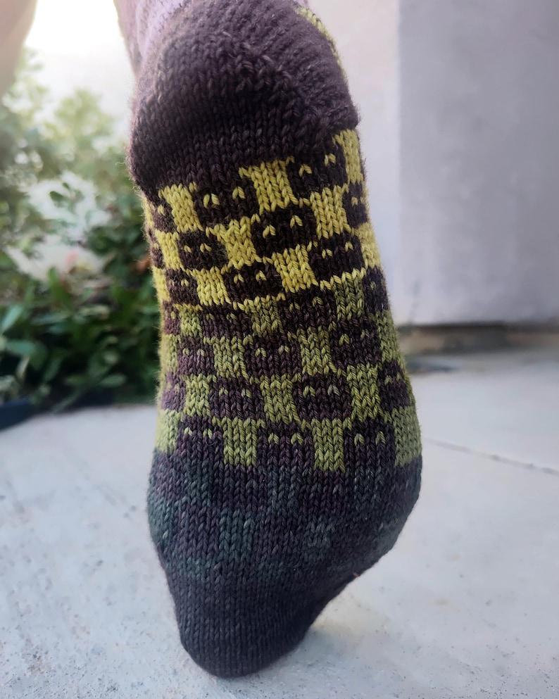 May include: A pair of brown and green socks with a checkered pattern in yellow and green.