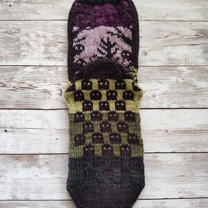 May include: A brown, green, and purple knitted sock with a checkered pattern. The sock is made with a variety of yarns and has a unique design.