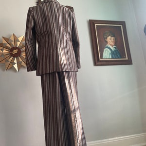 May include: A striped suit in brown and white with a long-sleeved jacket and wide-legged trousers.