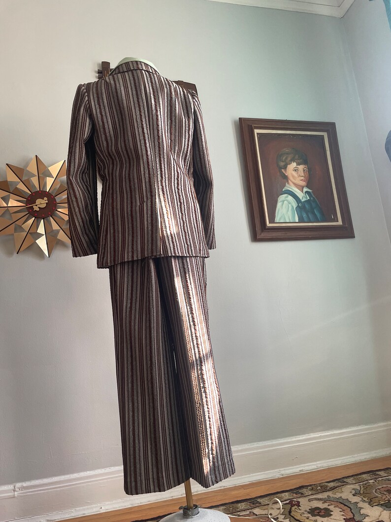 May include: A striped suit in brown and white with a long-sleeved jacket and wide-legged trousers.