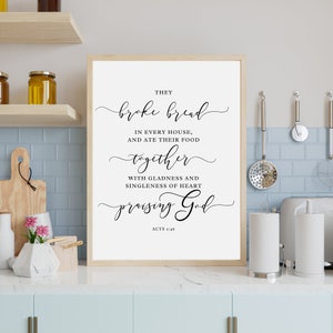 May include: A black and white printable wall art print with a quote from the Bible, Acts 2:46, that reads "They broke bread in every house, and ate their food together with gladness and singleness of heart praising God."