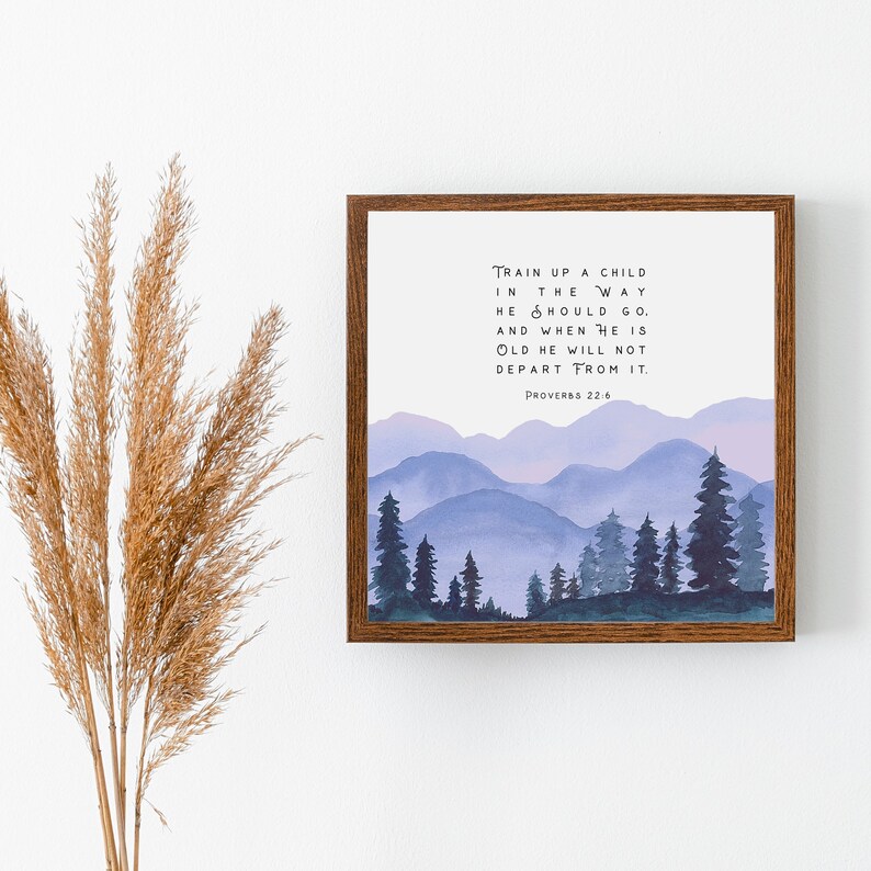 Puede incluir: Una impresi&oacute;n enmarcada con una ilustraci&oacute;n de acuarela de una cordillera con un cielo morado y azul. La impresi&oacute;n presenta el vers&iacute;culo b&iacute;blico "Instruye al ni&ntilde;o en el camino que debe andar, y aun cuando fuere viejo no se apartar&aacute; de &eacute;l. Proverbios 22:6"