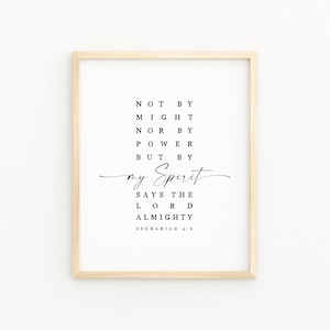 May include: A framed print with a light wood frame. The print features black text on a white background. The text reads "NOT BY MIGHT NOR BY POWER BUT BY my Spirit SAYS THE LORD ALMIGHTY ZECHARIAH 4:6."