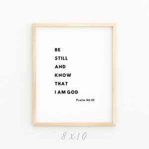 May include: A framed print with the text "Be still and know that I am God" and the scripture reference "Psalm 46:10". The print is in a light wood frame and measures 8x10 inches.