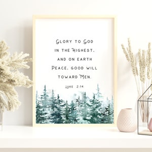 Peut inclure: Une impression encadr&eacute;e avec une illustration aquarelle d'une for&ecirc;t enneig&eacute;e. L'impression pr&eacute;sente le texte "Gloire &agrave; Dieu au plus haut. Et sur la terre paix, bonne volont&eacute; envers les hommes. Luc 2:14".