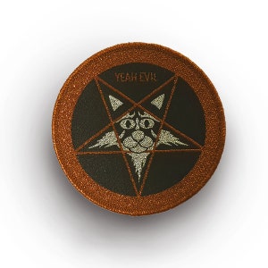 Könnte beinhalten: Ein runder, bestickter Aufnäher mit kupferfarbenem Rand. Die Mitte zeigt einen schwarzen Hintergrund mit einem silbernen Pentagramm-Design. Im Pentagramm befindet sich ein stilisiertes Katzengesicht in Silber. Der Text YEAH EVIL steht in Silber darüber.