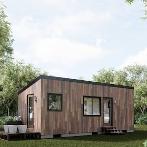 Op de afbeelding: Een kleine, moderne houten hut met een zwart dak en twee ramen. De hut heeft een houten terras met een kleine trap die naar de voordeur leidt.