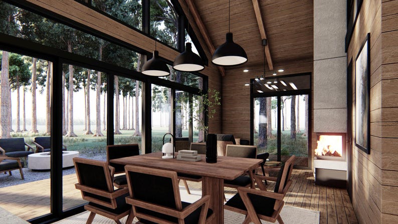 May include: Interior view of a modern dining room with large windows overlooking a forest. The room features a wooden dining table with chairs, pendant lights, and a fireplace. The walls and ceiling are made of wood.